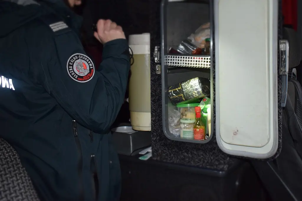 Польский таможенник проводит осмотр автомобильного холодильника